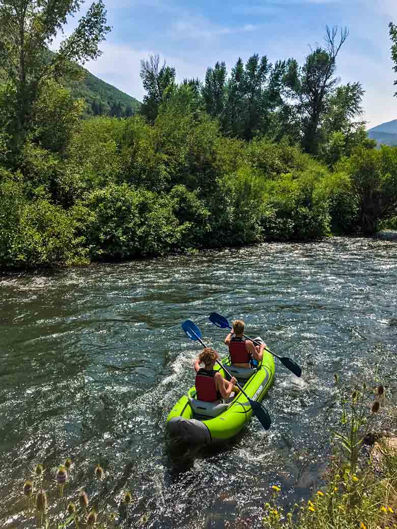 Two people kayaking on the Provo River near Orem and Park City Utah.