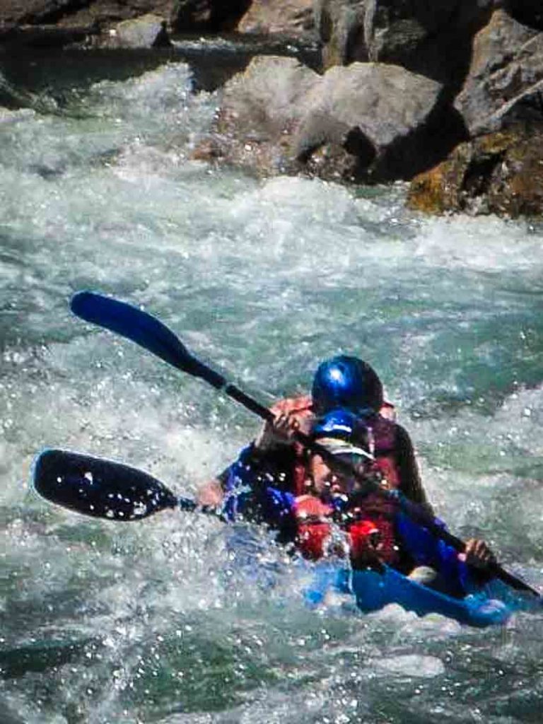 Two people whitewater kayaking on the Kern River in Kernville California.