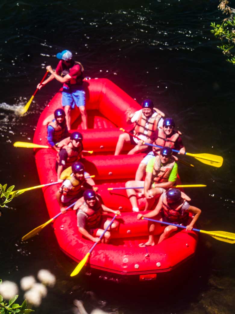 Men rafting in a red raft during a whitewater rafting trip on the Kern River near Kernville California.