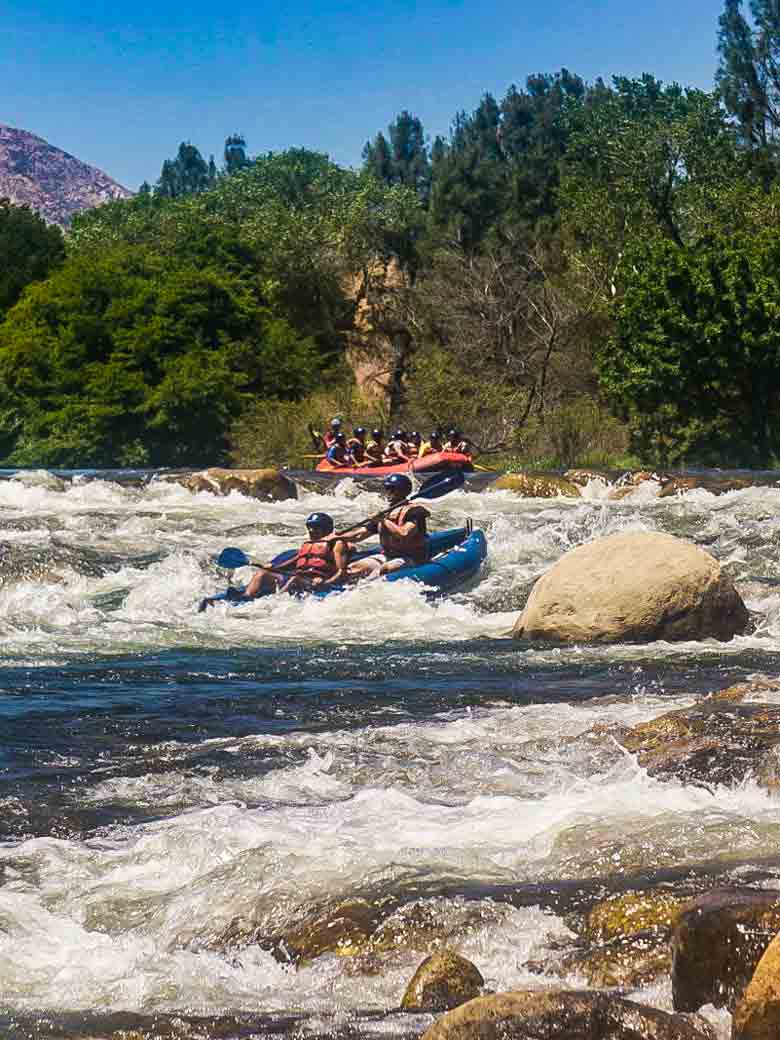 Two groups rafting and kayaking through Big Daddy rapid on the Kern River near Kernville California.