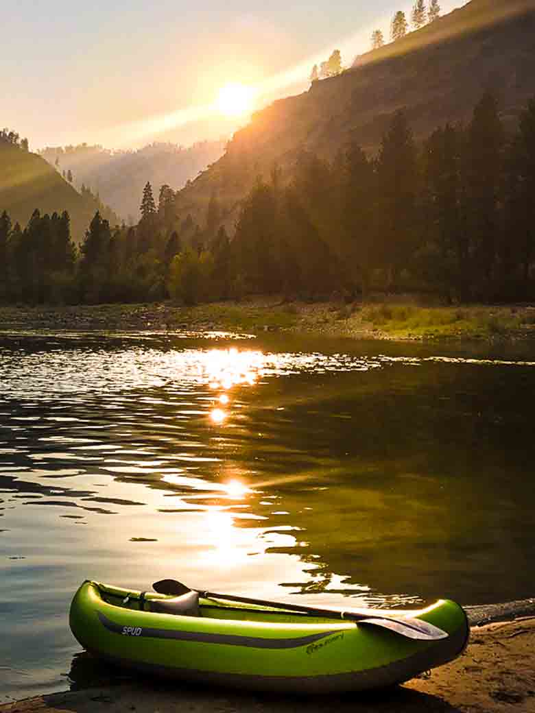A kayak in a beach at sunset during a Main Salmon River whitewater rafting vacation in Idaho.