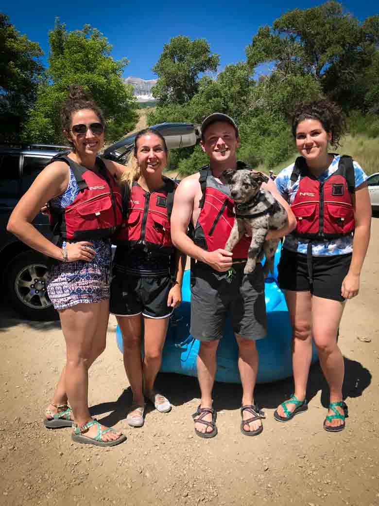 A group of people posing with a dog after a rafting and kayaking trip on the Provo River near Orem and Park City Utah.