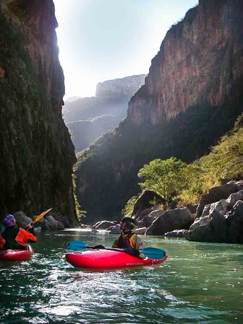 Two men kayaking in Copper Canyon during a whitewater river rafting trip in Mexico.