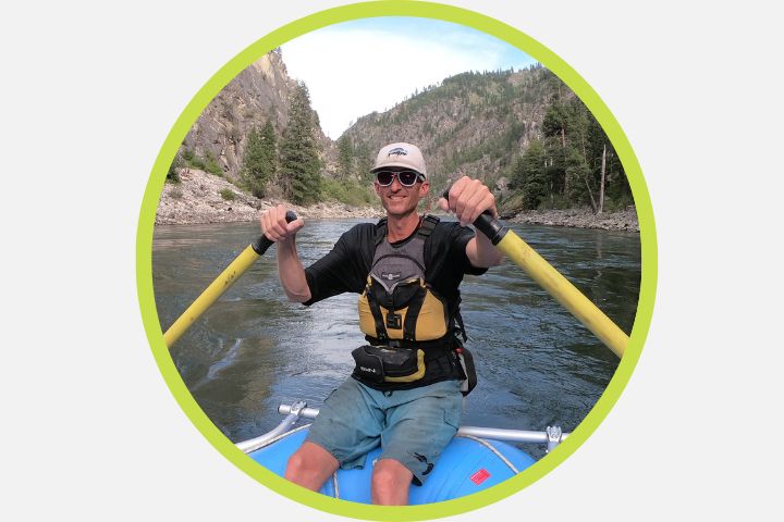 A man on a raft navigating the Provo River near Sundance and Bridal Veil Falls.