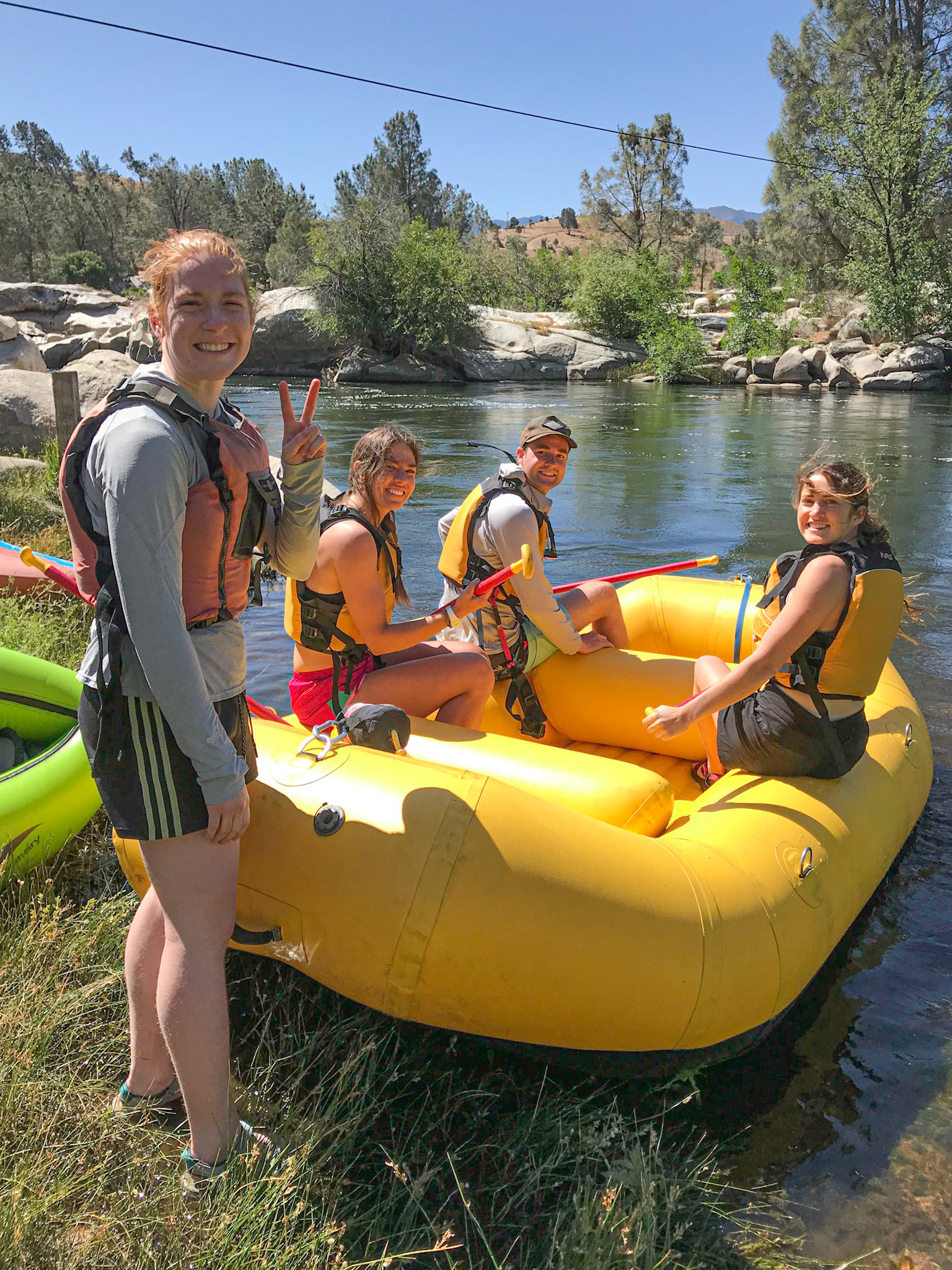 A group by the Kern River with a raft they rented from Kern River Rentals.